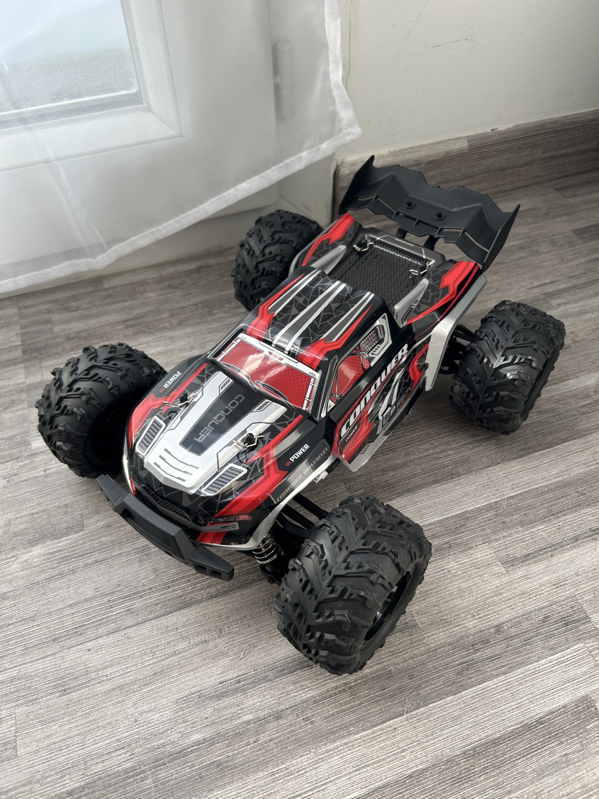 Monster RC sur chemin derrière une maison.