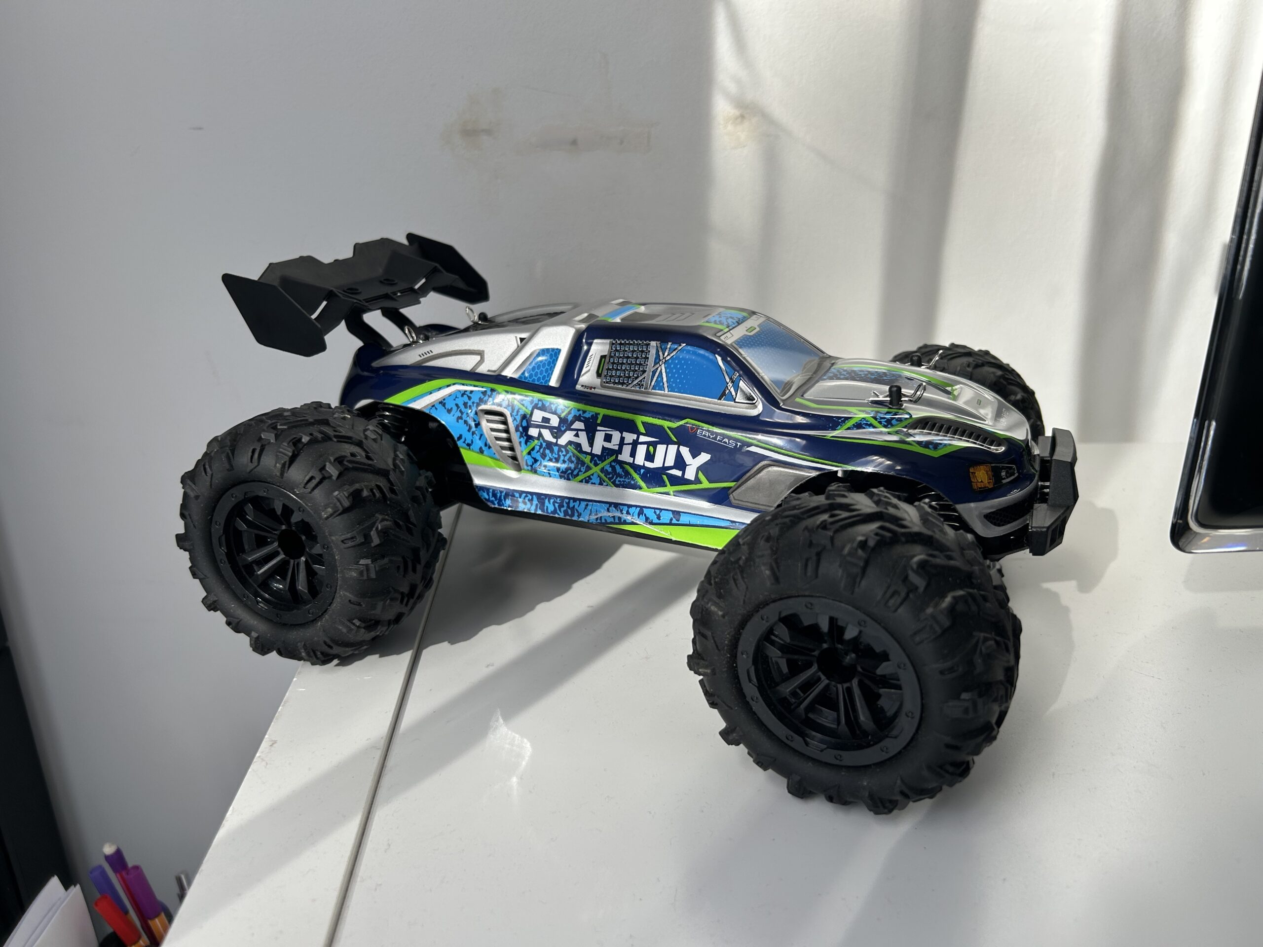 Voiture RC en run sur chemin sec et ensoleillé.