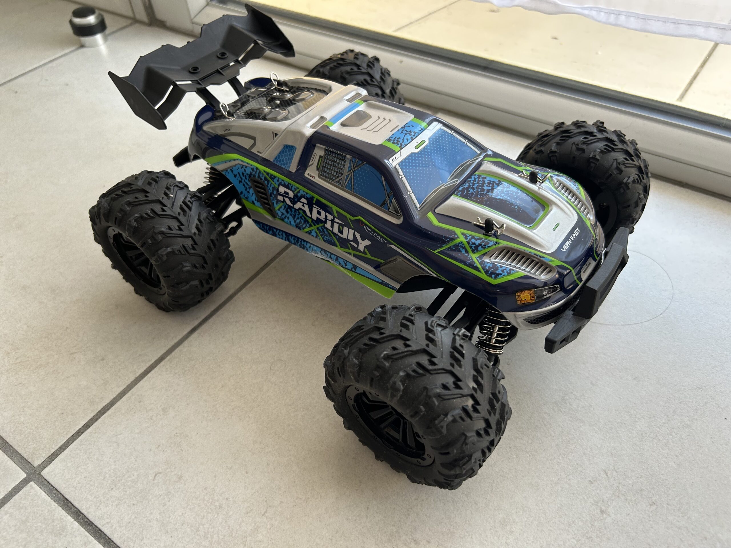 Voiture RC vue de profil sur terrain extérieur.